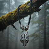 Necklace with wolf head pendant on a braided black cord against a white background
