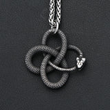 Silver snake pendant necklace on a dark background