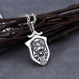 Silver pendant with lion design on a dark surface