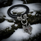 Necklace with wolf head pendant and braided black cord on white background