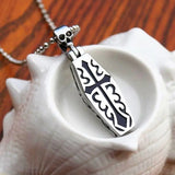 Silver pendant with cross design on a shell