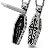 Two silver pendants with skeleton and cross designs on a white background