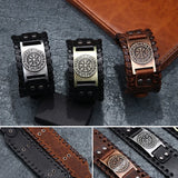 Three Viking leather bracelets with metal clasps on a textured surface