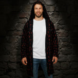 A man wearing a black hooded jacket with a red rune pattern design