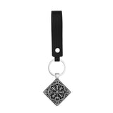 Keychain with black strap and decorative pendant on a white background