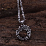 Silver necklace with a detailed pendant on a wooden surface