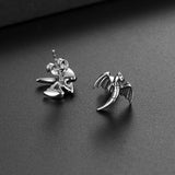 Silver dragon wing earrings on a dark surface