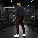 A man wearing black jogger-style pants with a repeating red circular viking symbol pattern, standing at the gym
