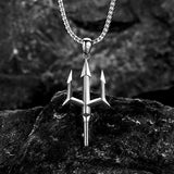 Silver trident pendant necklace on a dark stone surface